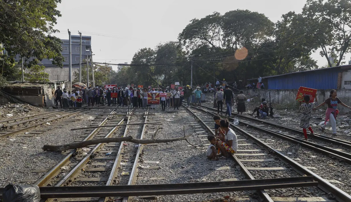 Demonstran berdiri di rel kereta api mengganggu layanan kereta selama protes terhadap kudeta militer di Mandalay, Myanmar (17/2/2021). Para demonstran menuntut junta militer membebaskan pemimpin de facto Myanmar Aung San Suu Kyi dan tokoh politik berpengaruh lainnya yang ditahan. (AP Photo)