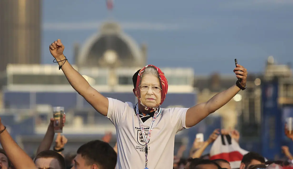 Suporter Inggris menggunakan topeng Ratu Elizabeth II saat menyaksikan laga Grup B Piala Eropa 2016 antara Inggris melawan Rusia di fan zone sekitar Menara Eiffel, Prancis, Sabtu (11/6/2016). (AFP/Geoffroy Van Der Hasselt)