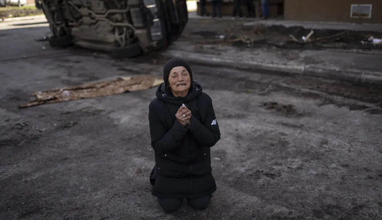 Tanya Nedashkivs'ka (57) berduka atas kematian suaminya YANG terbunuh di Bucha, di pinggiran Kiev, Ukraina, Senin, 4 April 2022. Perempuan itu berlutut di lumpur, tangannya terkepal dan wajahnya berubah sedih saat dia terisak-isak atas kematian suaminya. (AP Photo/Rodrigo Abd)