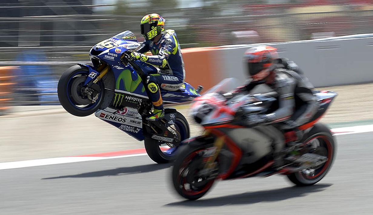 Pebalap Yamaha, Valentino Rossi, melakukan jumping wheelie saat latihan jelang GP Barcelona di Sirkuit Montmelo, Spanyol. (AFP/Josep Lago)
