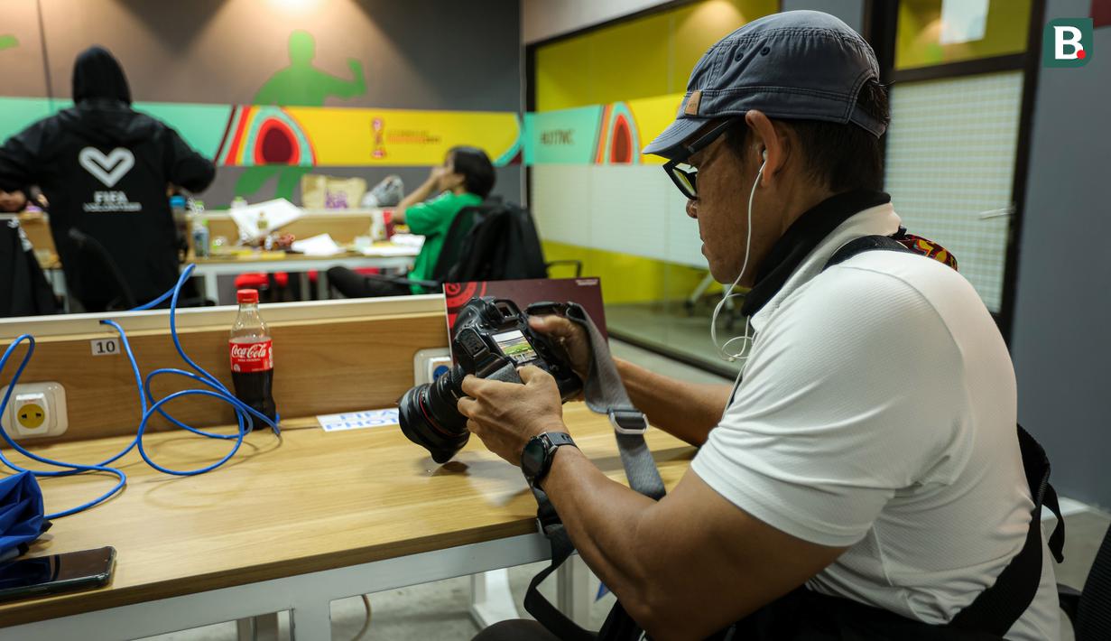 Seorang fotografer sedang melakukan pengetesan fasilitas yang berada di ruangan khusus wartawan untuk peliputan Piala Dunia U-17 2023 di Stadion Gelora Bung Tomo (GBT), Surabaya, Kamis (9/11/2023). Awak media bisa memanfaatkan keberadaan meja panjang, tempat duduk, colokan listrik, televisi, wifi, AC, kulkas, loker, toilet, hingga musala di media center Piala Dunia U-17 2023. (Bola.com/Bagaskara Lazuardi)
