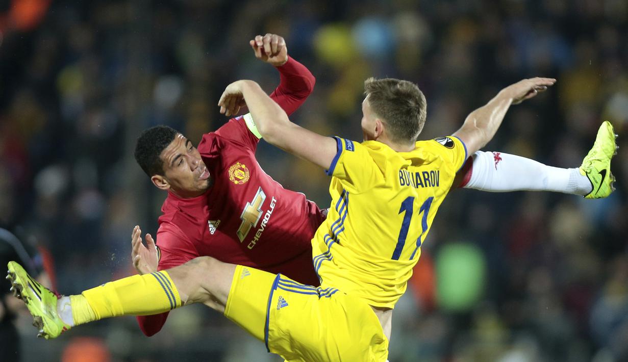 Duel pemain Manchester United, Chris Smalling (kiri) dan pemain FC Rostov, Aleksandr Bukharov pada leg pertama Babak 16 Besar Liga Europa di OLimp 2 Stadium Rostov-on-Don, Russia (9/3/2017). MU bermain imbang 1-1. (AP/Denis Tyrin)