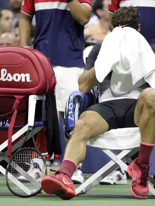 Roger Federer beristirahat sejenak saat melawan uan Martin del Potro pada laga perempat final AS Terbuka 2017 di Arthur Ashe Stadium, New York,(6/9/2017). Federer kalah 5-7, 6-3, 6-7, 4-6.  (AP/Julio Cortez)