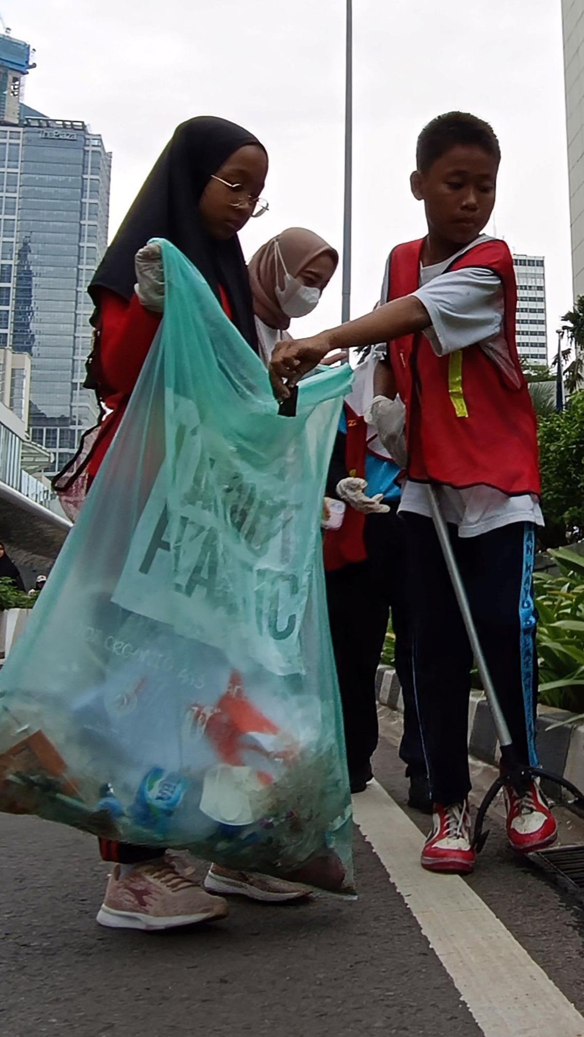 Anak-anak yatim-piatu memunguti sampah-sampah yang di kawasan Thamrin. Foto: merdeka.com / Arie Basuki