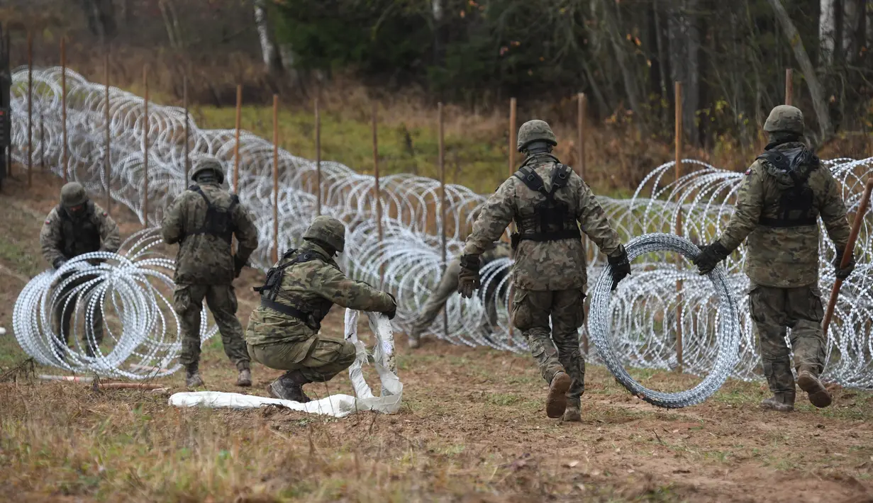 Tentara Polandia mulai memasang penghalang kawat berduri di sepanjang perbatasan Polandia dengan eksklave Rusia, Kaliningrad di Wisztyniec, Polandia, Rabu (2/11/2022).  Pagar kawat berduri tersebut dibangun di tengah kekhawatiran bahwa Kaliningrad sebagai daerah kantong mungkin menjadi saluran untuk migrasi ilegal. (AP Photo/Michal Kosc)