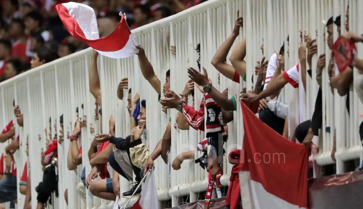 Dari balik pagar suporter  memberikan dukungan kepada Timnas Indonesia saat melawan Vietnam pada laga Semifinal AFF Cup 2016 di Stadion Pakansari, Bogor, (03/12/2016). (Bola.com/Nicklas Hanoatubun)