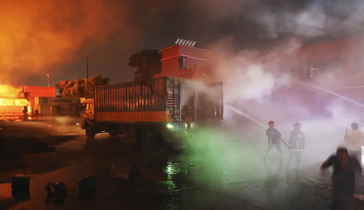 Petugas pemadam kebakaran berupaya memadamkan api yang berkobar di BM Inland Container Depot, perusahaan patungan Belanda-Bangladesh, di Chittagong, 216 kilometer (134 mil) tenggara ibu kota, Dhaka, Bangladesh, Minggu pagi (5/6/2022).Pejabat setempat melaporkan, kebakaran bermula usai ledakan besar yang memicu sejumlah ledakan kontainer di lokasi tersebut. (AP Photo)