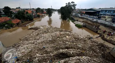 Tumpukan sampah yang tersangkut di jembatan Rawajati Kalibata, Jakarta, Selasa (8/3/2016). Hujan yang mengguyur Bogor dua hari terakhir mengakibatkan banjir kiriman yang disertai sampah batang bambu. (Liputan6.com/Helmi Fithriansyah)