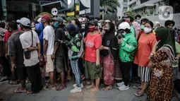 Warga dan pengemudi ojek daring antre makanan gratis di Sudirman, Jakarta, Jumat (8/5/2020). Bagi-bagi makanan ini sebagai bentuk kepedulian untuk pengemudi ojol dan warga terdampak kebijakan penanganan virus corona, seperti work frome home dan physical distancing. (Liputan6.com/Faizal Fanani)
