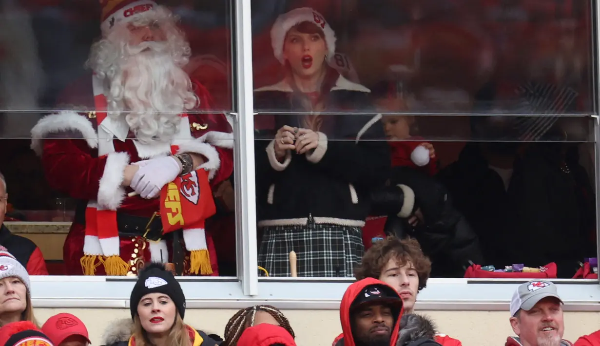 Kakak laki-laki Taylor Swift mengenakan kostum Santa Klaus lengkap dengan rambut dan jenggot palsu panjang. (Jamie Squire/Getty Images/AFP)