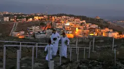 Kaum Samaritan berjalan menuju puncak Gunung Gerizim untuk melakukan doa dalam perayaan hari Sukkot di Israel (4/10). Gunung Gerizim merupakan tempat pusat ibadah kaum Samaritan, dan daerah yang dianggap paling suci. (AFP Photo/Jaafar Ashtiyeh)