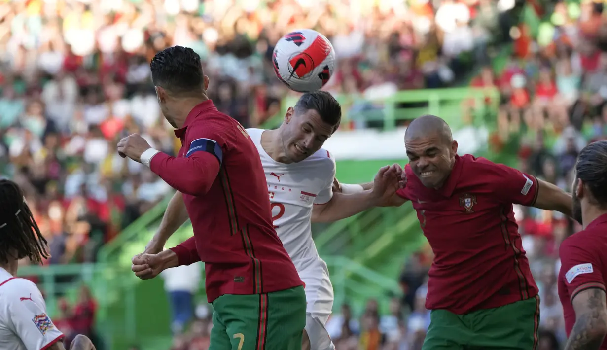 Bek Swiss, Fabian Schaer berusaha menyundul bola dari kawalan bek Portugal, Pepe pada pertandingan kedua Grup A2 UEFA Nations League di Stadion Jose Alvalade di Lisbon, Senin (6/6/2022). Portugal menang telak atas Swiss 4-0. (AP Photo/Armando Franca)