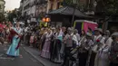 Orang-orang yang mengenakan pakaian tradisional 'chulapo' menari selama perayaan San Cayetano, santo pelindung tenaga kerja dan roti, di lingkungan Lavapies di Madrid, Spanyol, Sabtu (6/8/2022). Festival San Cayetano menandai awal dari serangkaian festival populer di Madrid. (AP Photo/Manu Fernandez)