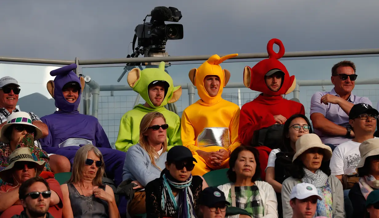 Penonton mengenakan kostum Teletubbies menyaksikan pertandingan antara  Adrian Mannarino dari Prancis melawan pemain Kroasia Marin Cilic selama babak pertama tunggal putra hari kedua Kejuaraan Wimbledon 2019 di All England Lawn Tennis Club di Wimbledon, London (2/7/2019). (AFP Photo/Adrian Dennis)