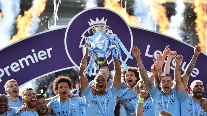 Kapten Manchester City, Vincent Kompany, mengangkat trofi juara Premier League 2018-2019, Minggu malam WIB (12/5/2019). (AFP/Glyn Kirk)