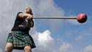 Meagan McKee melempar palu saat mengikuti Grandfather Mountain Highland Games ke-64 di MacRae Meadows, Linville, North Carolina, AS, Jumat (12/7/2019). Kejuaraan ini digelar untuk merayakan sejarah dan budaya Skotlandia. (AP Photo/Chuck Burton)