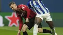 Gelandang AC Milan Alexis Saelemaekers berebut bola dengan bek FC Porto, Zaidu Sanusi pada matchday kelima Grup B Liga Champions di San Siro, Kamis (4/11/2021) dini hari WIB. AC Milan  makin terpuruk setelah hanya mampu bermain imbang dengan Porto 1-1. (AP Photo/Luca Bruno)