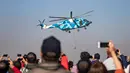 Penonton mengambil gambar helikopter serba guna Z-8 yang tampil dalam perayaan HUT ke-70 Angkatan Udara Tentara Pembebasan Rakyat di Changchun, Provinsi Jilin, Kamis (17/10/2019). Ada penerbangan aerobatik, pertunjukan parasut hingga demonstrasi pasukan khusus udara. (STR/AFP)