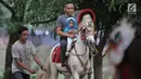 Seorang pria bersama anaknya menunggangi kuda saat menunggu waktu berbuka puasa atau ngabuburit di kawasan Kanal Banjir Timur, Jakarta, Selasa (5/6). Warga cukup mengeluarkan uang sebesar Rp 10 ribu untuk menaiki kuda. (Merdeka.com/Iqbal S. Nugroho)
