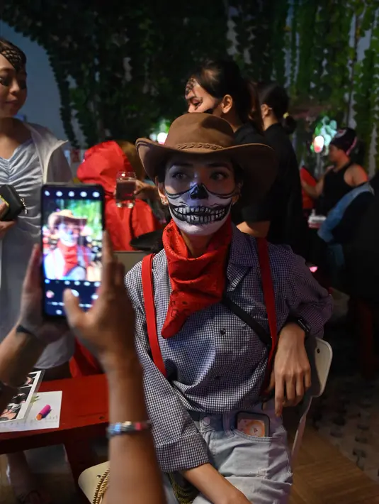 Orang-orang menghadiri pesta Halloween di sebuah kafe di Tangerang (31/10/2021). (AFP/Adek Berry)