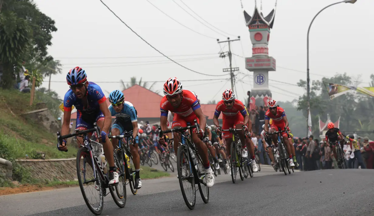 Para pebalap memacu sepedanya dalam Etape 3 Tour de Singkarak 2015 antara Sijunjung menuju Dharmasraya, Sumatra Barat, Senin (5/10/2015). (Bola.com/Arief Bagus)