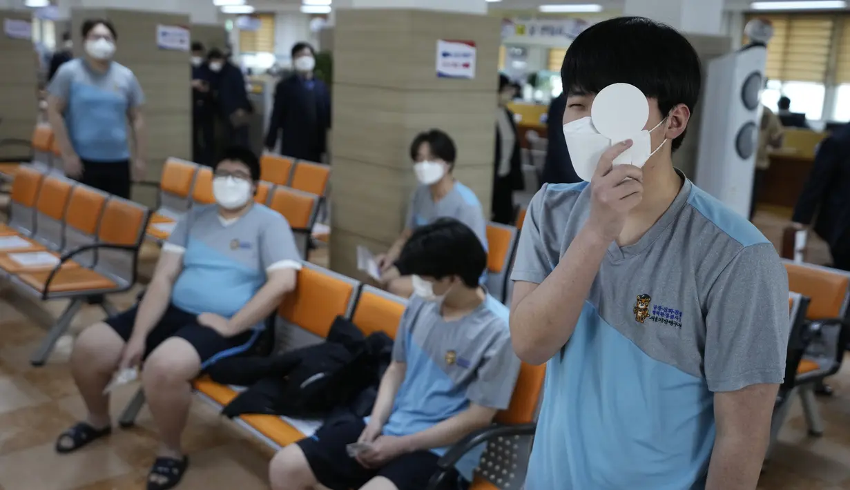 Seorang calon tentara Korea Selatan yang mengenakan masker tes mata saat menjalani pemeriksaan kesehatan untuk wajib militer di kantor Administrasi Tenaga Kerja Militer Seoul di Seoul, Senin (7/2/2022). (AP Photo/Ahn Young-joon)