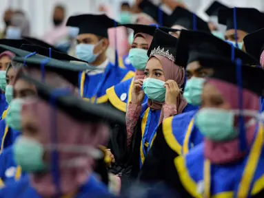 Sejumlah pelajar yang memakai masker sebagai tindakan pencegahan terhadap virus corona COVID-19 mengikuti acara wisuda SMK Farmasi di Banda Aceh (24/9/2020). (AFP/Chaideer Mahyuddin)