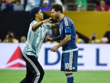 Seorang fans Argentina turun ke lapangan hanya untuk memeluk Lionel Messi saat laga semifinal Copa America Centenario  2016 antara Argentina vs Amerika Serikat di Houston, Texas, Rabu (22/6/2016) WIB. (AFP/Omar Torres)
