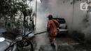 Petugas melakukan pengasapan (fogging) di halaman rumah warga, Pesanggrahan, Jakarta, Kamis (6/10/2022). Musim hujan menjadi waktu krusial bagi nyamuk untuk berkembangbiak. (Liputan6.com/Johan Tallo)