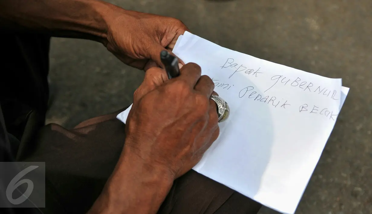 Seorang tukang becak saat menuliskan surat untuk Gubernur DKI, Basuki Tjahaja Purnama saat melakukan unjuk rasa di Balai Kota Jakarta, Kamis (28/1). Aksi tersebut terkait larangan para tukang becak untuk beroperasi. (Liputan6.com/Yoppy Renato)