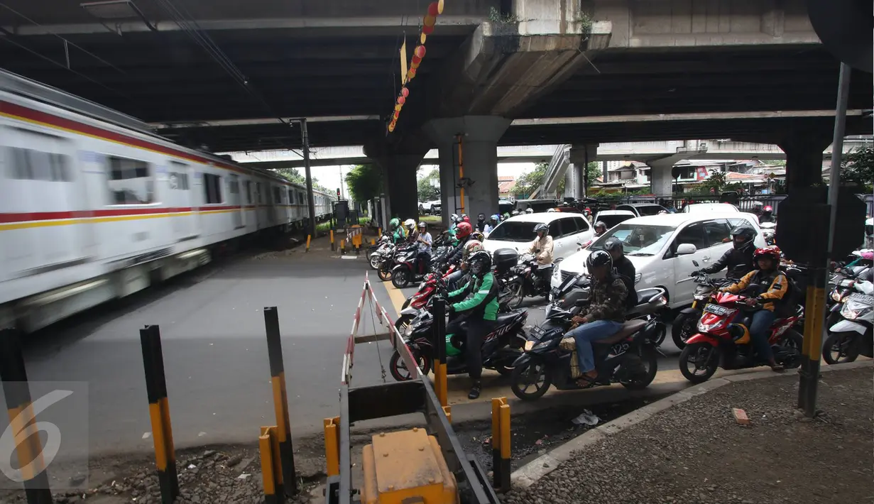 Kendaraan menunggu kereta melintas di kawasan Tanjung Barat, Jakarta, Rabu (8/3). Dirjen Perkeretaapian Kemenhub berkoordinasi dengan Pemprov DKI dan Polda Metro Jaya akan menutup empat perlintasan sebidang, Mei 2017. (Liputan6.com/Immanuel Antonius)