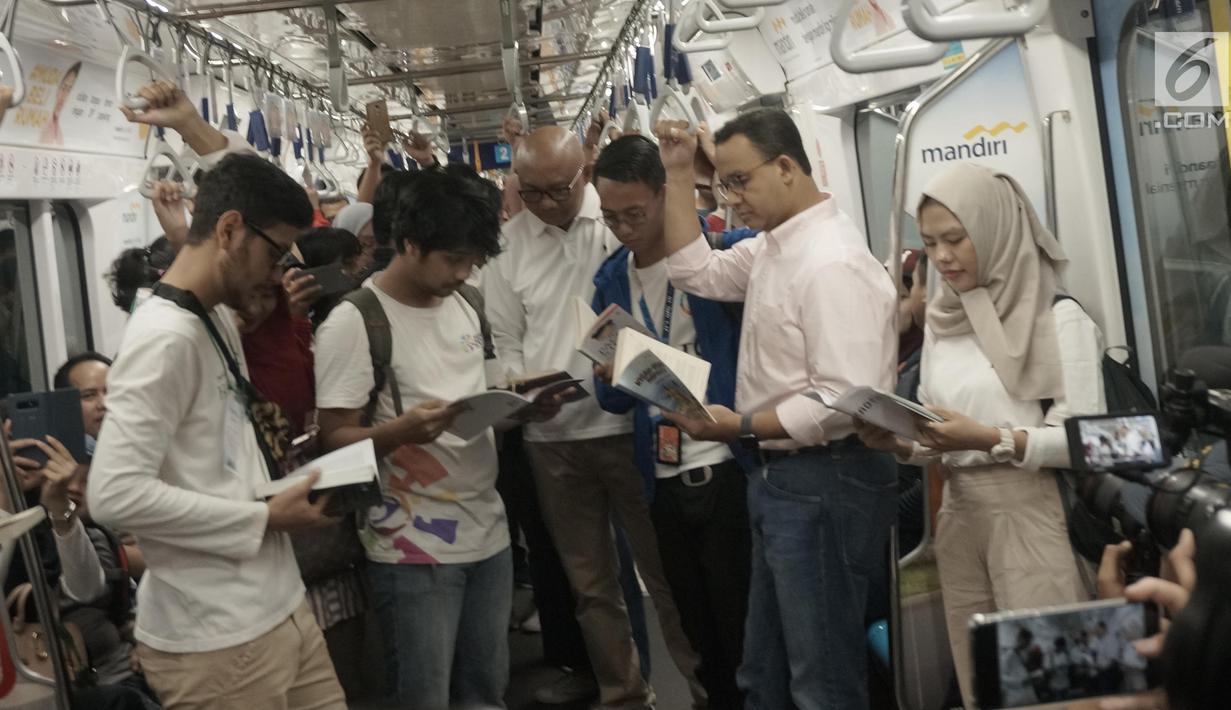 Gubernur DKI Anies Baswedan bersama masyarakat pengguna MRT tengah membaca buku yang disediakan disetiap stasiun MRT di Jakarta, Minggu (8/9/2019). Pemprov DKI Jakarta  meluncurkan ruang baca buku disetiap stasiun MRT untuk menumbuhkan minat baca masyarakat.(Liputan6.com/Angga Yuniar)