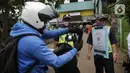 Pengunjung memindai "barcode" melalui aplikasi PeduliLindungi sebelum memasuki Pasar Anyar di Kota Tangerang, Selasa (26/10/2021). PD Pasar Kota Tangerang memberlakukan penerapan aplikasi PeduliLindungi di dua pasar tradisional, yakni Pasar Anyar dan Pasar Poris. (Liputan6.com/Angga Yuniar)