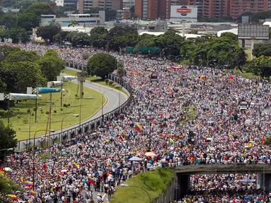 Ribuan pendukung kelompok oposisi turun ke jalan saat unjuk rasa anti-Presiden Nicolas Maduro di Caracas, Venezuela (26/10). Unjuk rasa bertajuk "Ambil Alih Venezuela" ini menuntut adanya referendum untuk melengserkan Maduro. (REUTERS/Christian Veron)