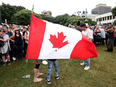 Bendera Kanada berkibar di halaman parlemen pada hari ketiga demonstrasi menentang pembatasan Covid-19, terinspirasi oleh demonstrasi serupa di Kanada, di Wellington (10/2/2022). (AFP/Marty Melville)