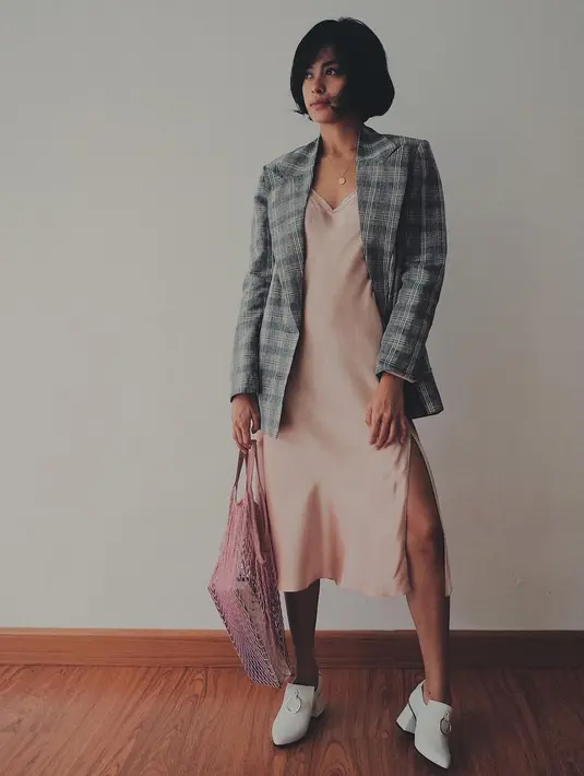 Seperti ini contohnya, Eva mengenakan dress dengan belahan samping yang tinggi. Ia memadukannya dengan blazer kotak-kotak dan sepatu heelsnya yang membuat tubuhnya makin terlihat jenjang. (Instagram/evacelia)