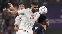 Pemain Tunisia,&nbsp;Ben Slimane berebut bola dengan pemain Prancis, Kingsley Coman saat matchday ketiga Grup D Piala Dunia 2022 yang berlangsung di Education City Stadium, Rabu (30/11/2022). (AP/Christophe Ena)