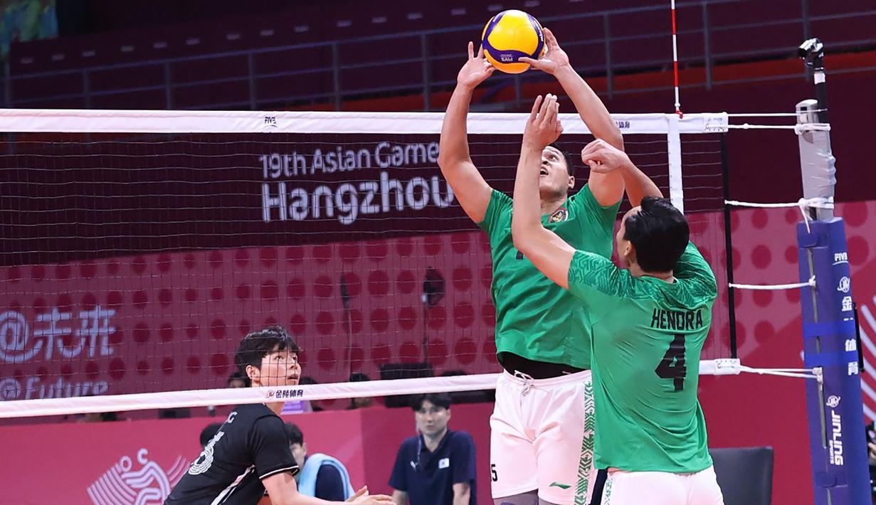 Pemain Timnas bola voli putra Indonesia, Dio Zulfikri (tengah) memberi umpan kepada rekannya, Hendra Kurniawan saat menghadapi Korea Selatan pada laga perebutan peringkat 7-8 Asian Games 2022 di LSC Gymnasium, Hangzhou, China, Selasa (26/9/2023) siang WIB. (AVCVolley)