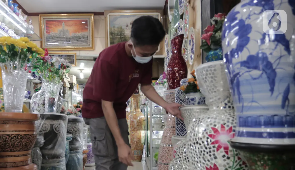 Pembeli melihat produk keramik yang dijual di kios kerajinan keramik kawasan Tanjung Priuk, Jakarta Utara, Kamis (23/9/2021). Pedagang mengaku pasokan keramik menurun hingga 70 persen seiring dangan pembatasan produksi pabrik akibat perpanjangan PPKM. (Liputan6.com/Herman Zakharia)