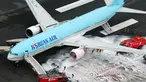 Gambar udara menunjukkan petugas pemadam kebakaran menyemprotkan busa pada mesin pesawat Korean Air Lines setelah asap keluar dari bagian mesin sebelah kiri itu di bandara Haneda di Tokyo, Jepang, (27/5). (Reuters/ Kyodo)