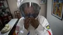 Akuntan Brasil Tercio Galdino (66) mengenakan helm saat akan pergi ke Pantai Copacabana dengan pakaian pelindung mirip astronaut di Rio de Janeiro, Brasil, 12 Juli 2020. Pakaian tersebut juga dipakai untuk bersenang-senang karena minatnya yang besar dalam astronomi. (Mauro Pimentel/AFP)