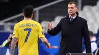 Pelatih Ukraina, Andriy Shevchenko, memberikan selamat kepada anak asuhnya, Mykola Shaparenko, usai melawan Prancis pada laga Kualifikasi Piala Dunia di Stadion Saint Denis, Paris, Kamis (25/3/2021). Kedua tim bermain imbang 1-1. (AFP/Franck Fife)