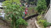 puluhan warga Tunjung, Kabupaten Bangkalan, gotong royong berishkan sedimentasi di kali yang melintasi pemukiman warga.
