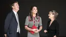 Kate Middleton mendengarkan penjelasan saat pembukaan pameran di Victoria and Albert Museum di London, Kamis (29/6). Kate juga menambahkan aksesori sederhana yakni tas tangan berwarna merah dan cincin berwarna hitam di jarinya (AP Photo/Alastair Grant)