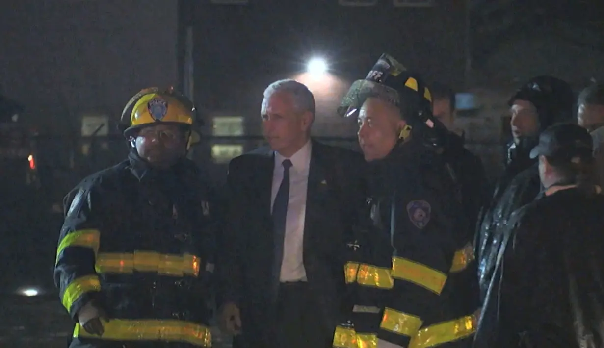 Cawapres AS dari Partai Republik, Mike Pence berbincang dengan petugas setelah pesawat yang ditumpanginya tergelincir di salah satu landasan pacu bandara La Guardia, New York, saat mendarat, Kamis (27/10). (TV Network Pool via AP)