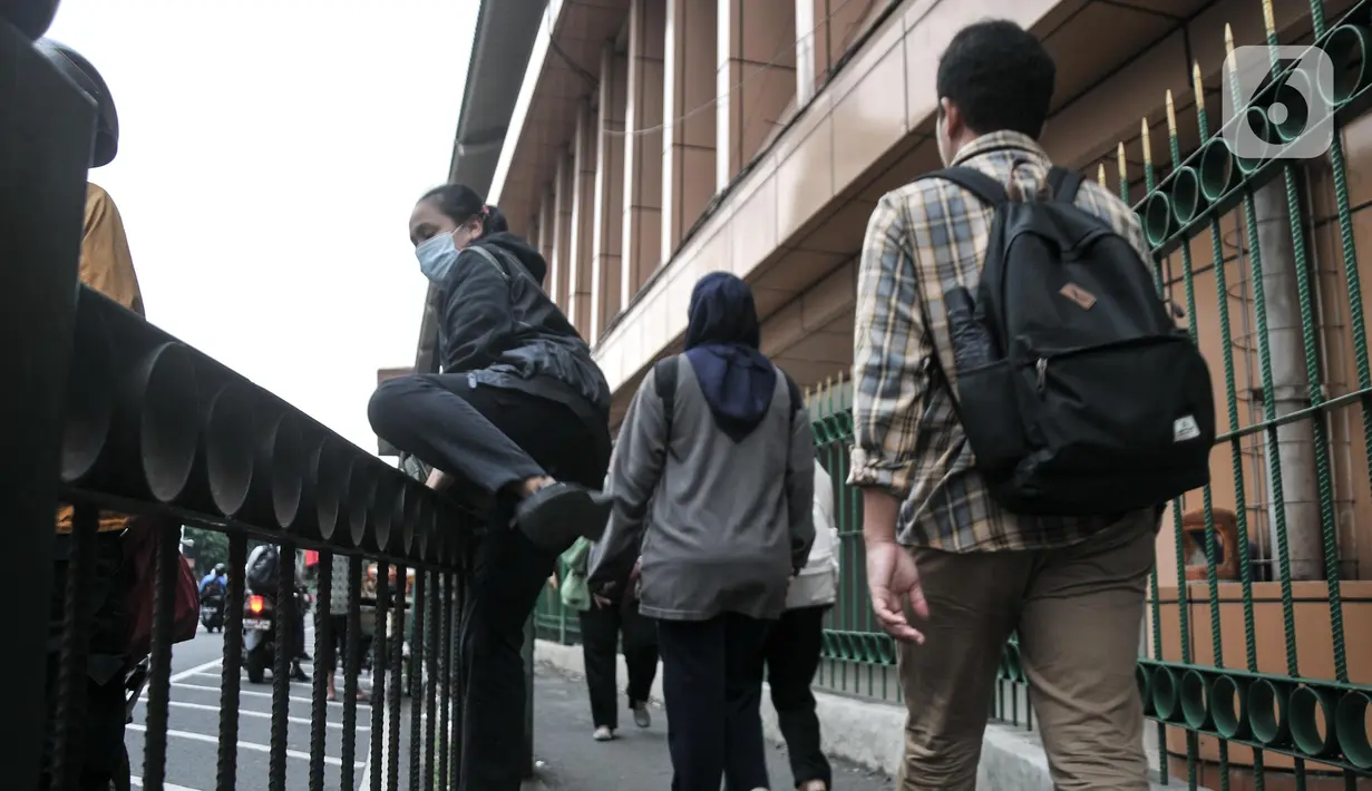 Pagar pembatas trotoar ini kerap menjadi jalan pintas pejalan kaki meski telah terpasang spanduk larangan untuk melompati pagar tersebut. (merdeka.com/Iqbal S.Nugroho)