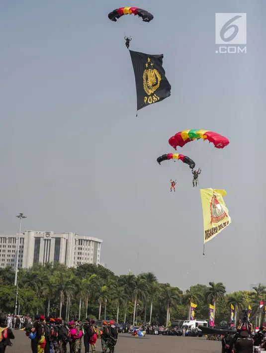 Penerjun payung bersiap mendarat saat tampil dalam perayaan HUT ke-73 Bhayangkara di Monas, Jakarta, Rabu (10/7/2019). Sebanyak 22 penerjun payung dari TNI dan Polri ikut menyemarakkan HUT ke-73 Bhayangkara. (Liputan6.com/Faizal Fanani)