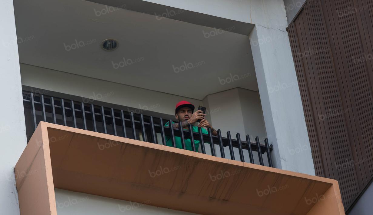 Gelandang Timnas Indonesia, Stefano Lilipaly, bermain handphone saat berada di balkon Hotel Aston Sentul, Jawa Barat, Rabu (14/12/2016). (Bola.com/Vitalis Yogi Trisna)