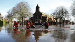 Petugas mengevakuasi warga menggunakan perahu karet di Carlisle, Inggris, Minggu (6/12). Puluhan ribu rumah tidak punya listrik karena Badai Desmond yang menyebabkan banjir di Inggris utara dan sebagian wilayah Skotlandia. (REUTERS/Phil Noble)