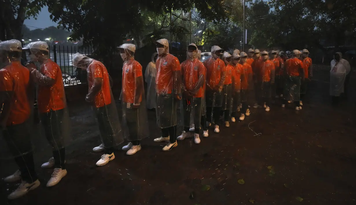 Anak-anak sekolah berbaris untuk pemeriksaan keamanan sebelum gladi bersih upacara Hari Kemerdekaan di monumen Benteng Merah saat hujan di New Delhi, India, Kamis, (13/8/2020). India akan  merayakan Hari Kemerdekaan ke-74 pada 15 Agustus. (AP Photo / Manish Swarup)